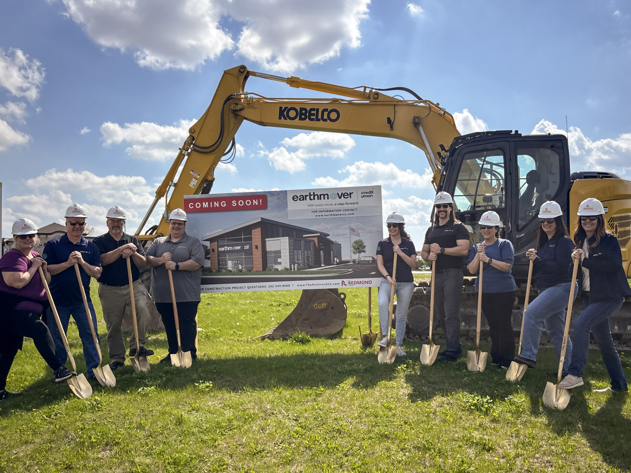 Group of people with shovels in front of a bulldozer