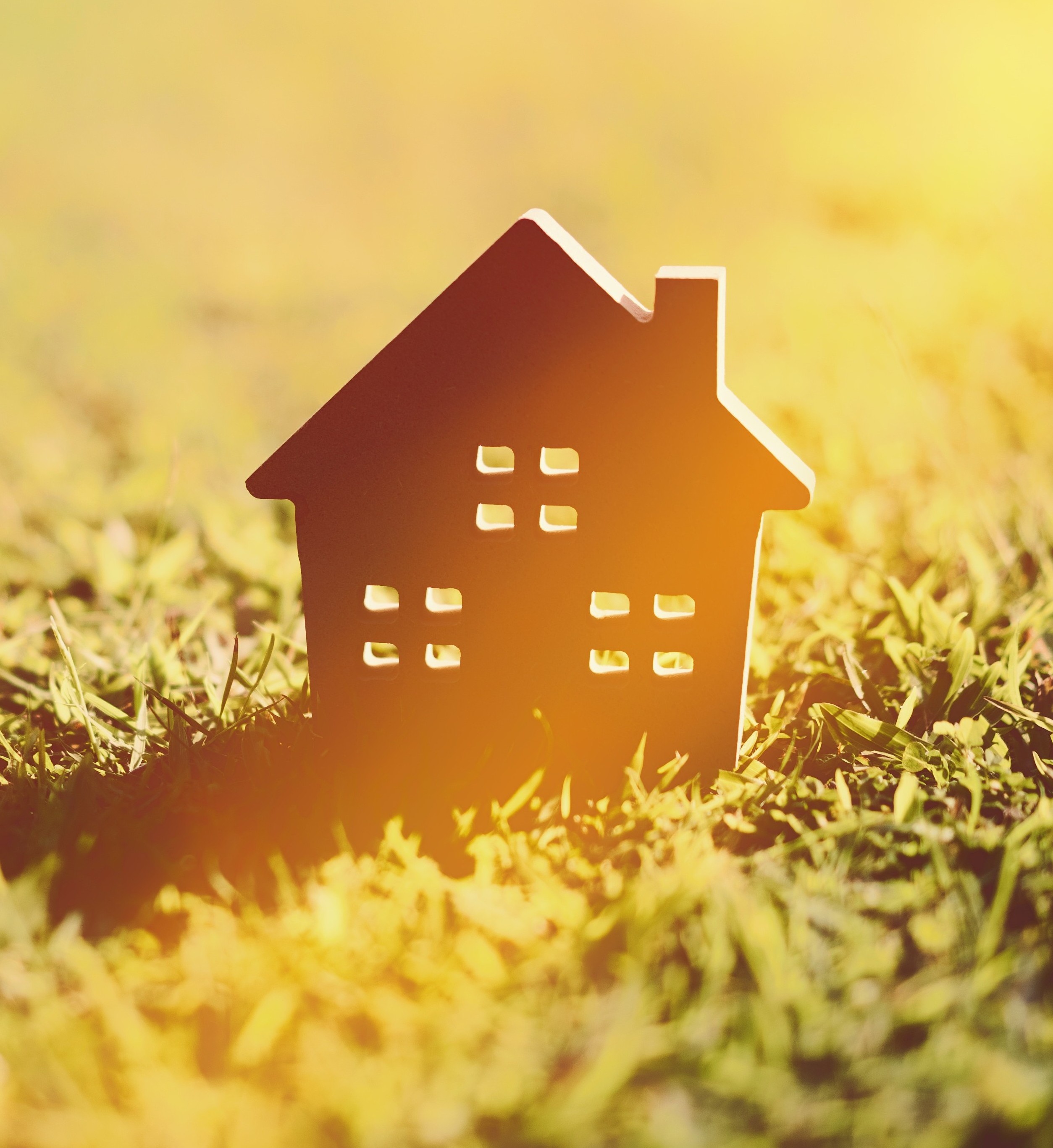 Paper cutout of house on grass