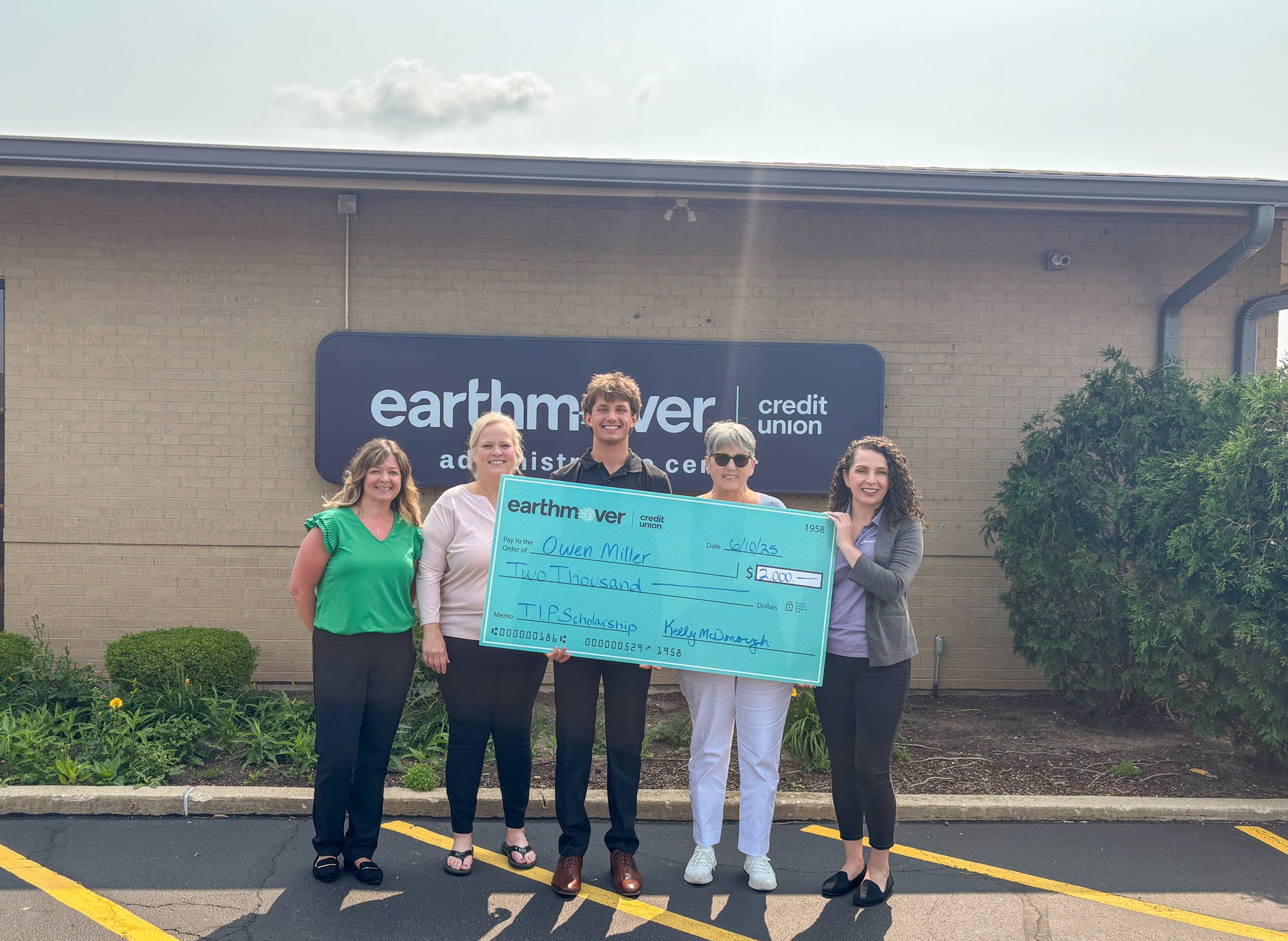 Group posing with large check